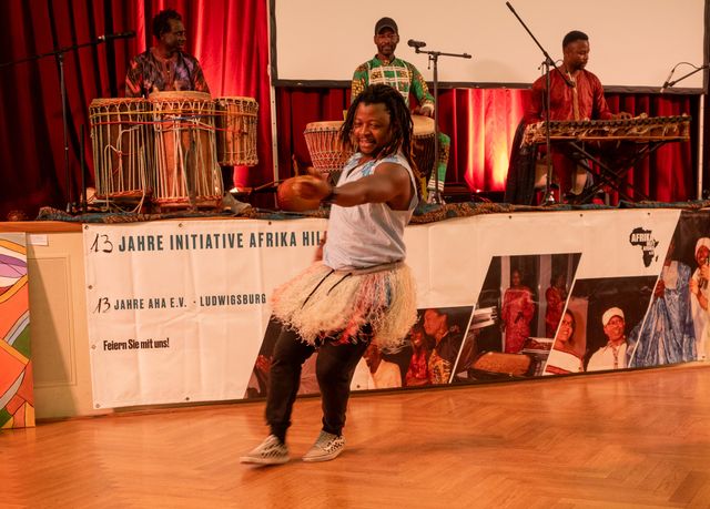Tänzer im Raffiakostüm vor der Trommelgruppe des Afrikagalas